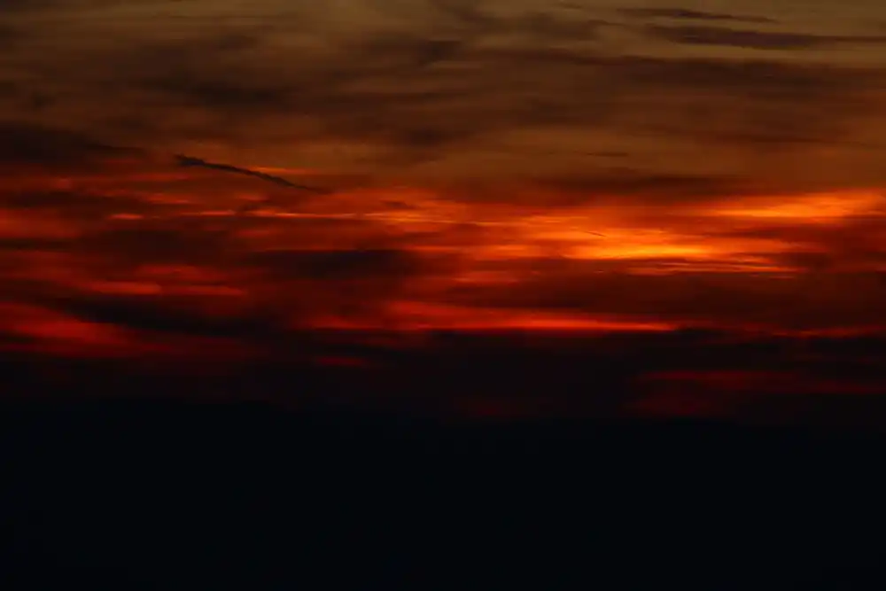 Ciel strié de nuages rouge sang au crépuscule.