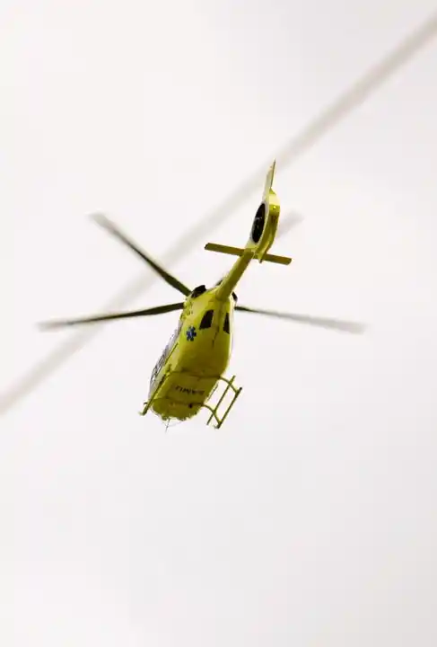 Hélicoptère de secours s'alignant sur des lignes électriques.